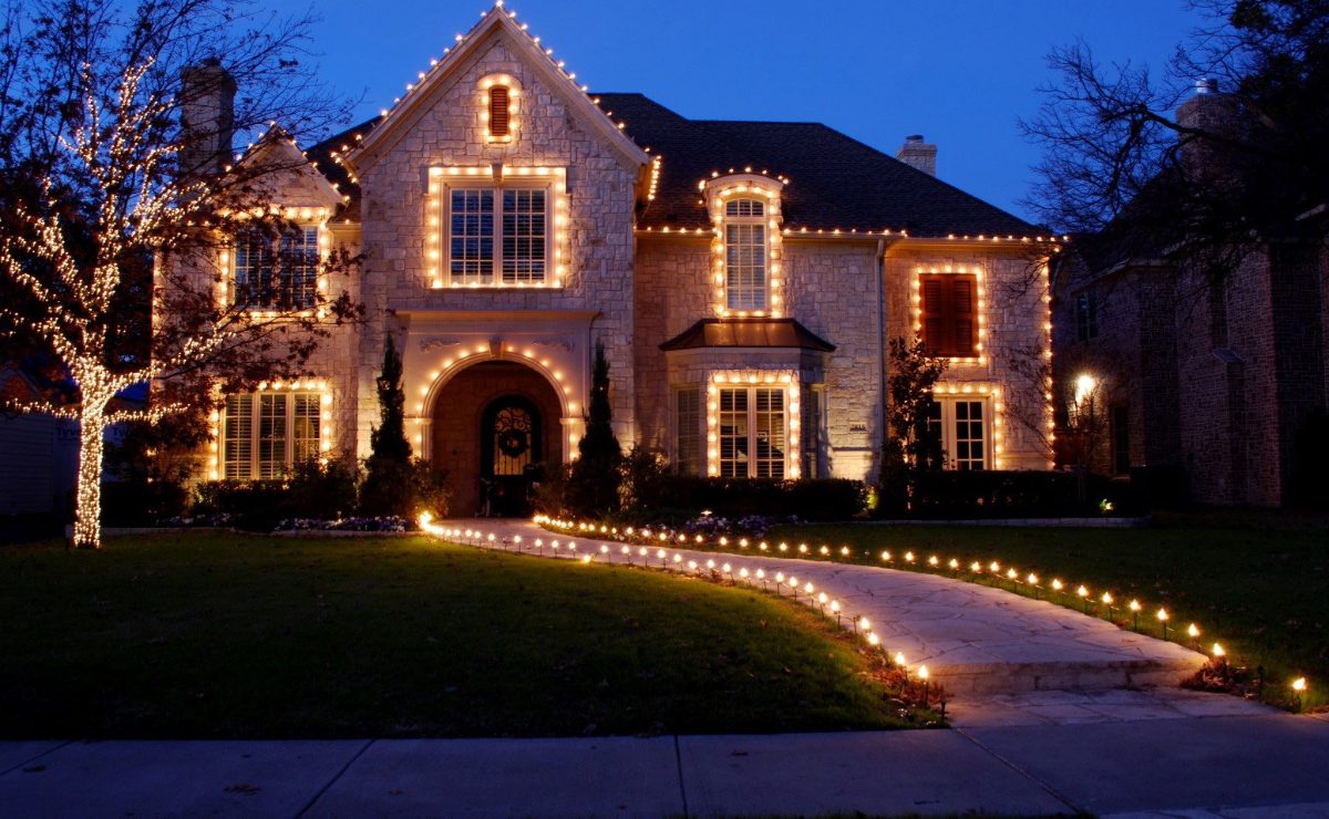 Professional holiday light installation on a Long Island home at dusk — rooflines and walkway lit by Clean N' Go Power Washing